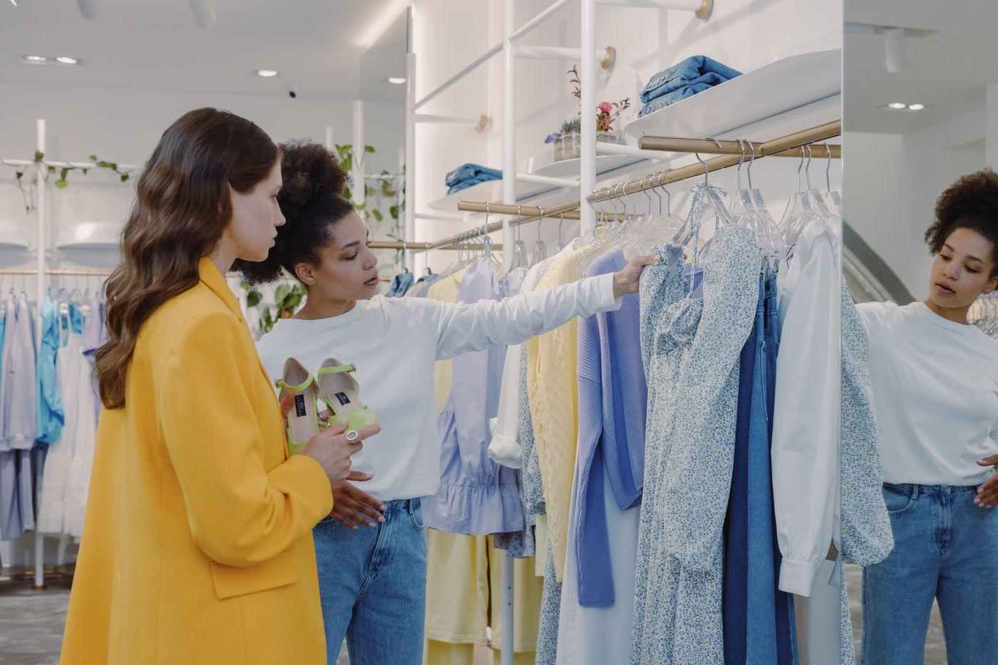 Two shoppers discovering clothing and styling outfits in a boutique