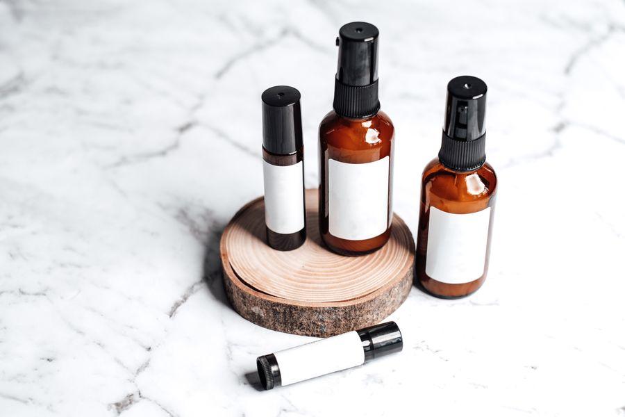 Amber skincare bottles and personal-care products on a wooden tray